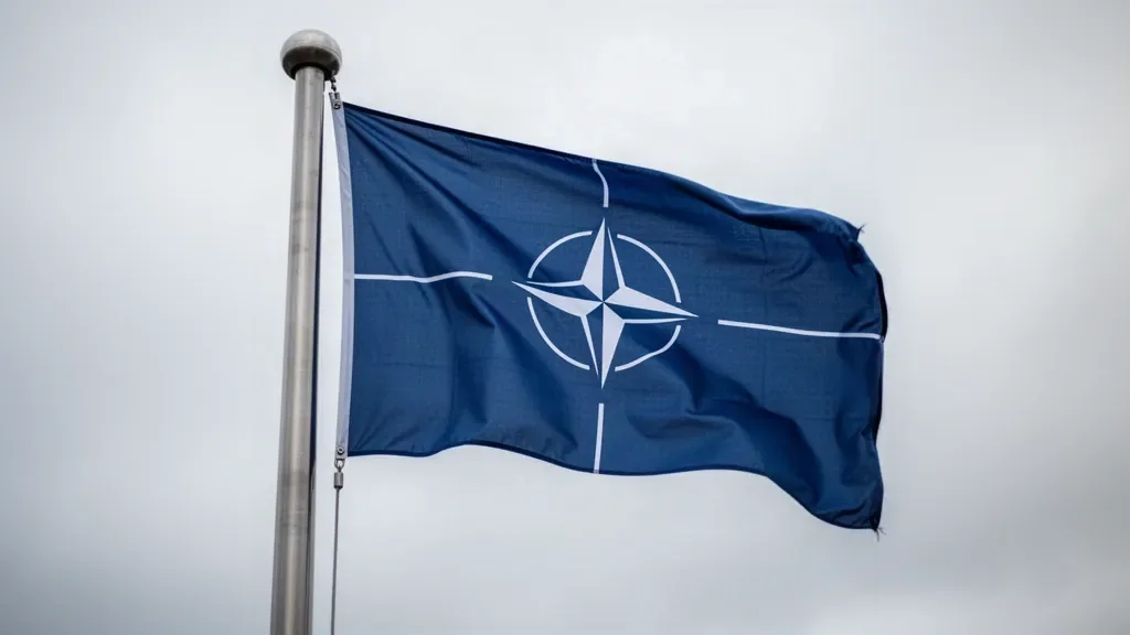 Прапор НАТО майорить на металевому флагштоці біля штаб-квартири організації