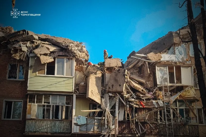 Обломки бетона, кирпич и остатки поврежденной кровли возле стены жилого здания после взрыва